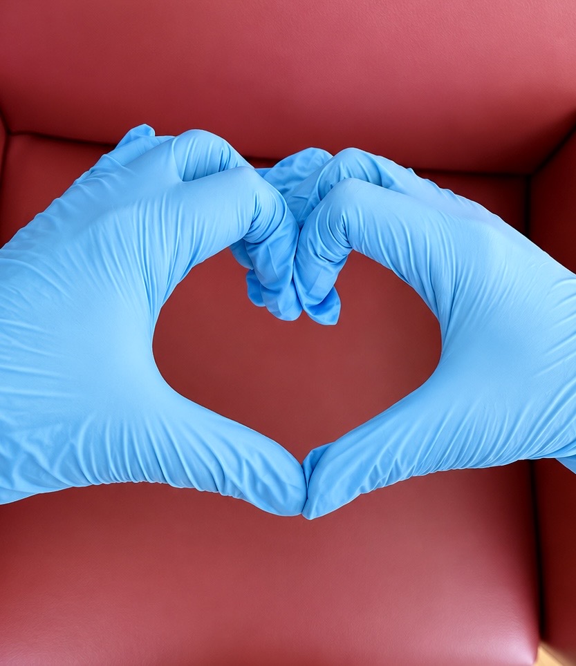 Herz aus Händen mit blauen Handschuhen – Pflege aus Leidenschaft